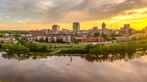 Aerial view of downtown New Brunswick and Rutgers University as the sun sets behind the high rise buildings and reflect on the Raritan river