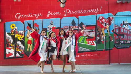 (l. to r.) Stephanie Huembes (SAS ’25), Lindsay Levine (SAS ’25), Ishika Borad (SAS ’25), and Nathalie Huembes (SAS/SCI ’25) celebrate in front of the Rutgers Greetings from Piscataway mural in SHI Stadium before 259th anniversary Commencement for Rutgers University–New Brunswick and Rutgers Health class of 2025.