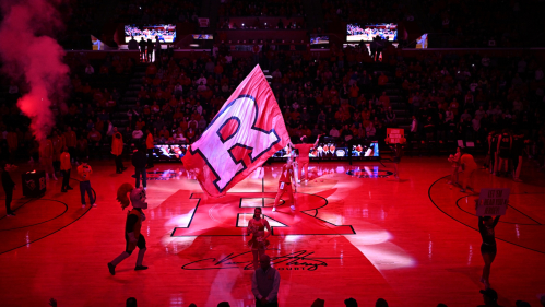 The Rutgers Block R flag being carried around the basketball court