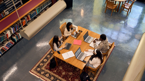 students studying at a table in the library