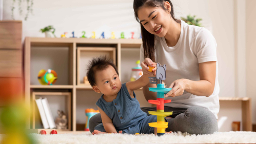 A woman playing and teaching her baby