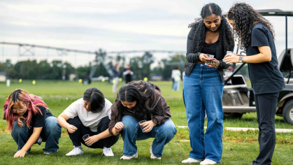 Rutgers Honors students (three squatting and two standing) examine turfgrass at Adelphia Farm in Freehold, N.J. on Sept. 11.