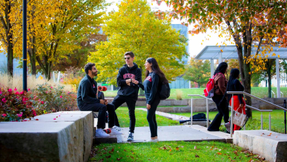 A trio of Rutgers students talking together in an outdoors setting