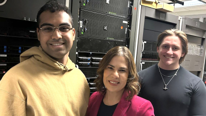 Three people standing in a server room