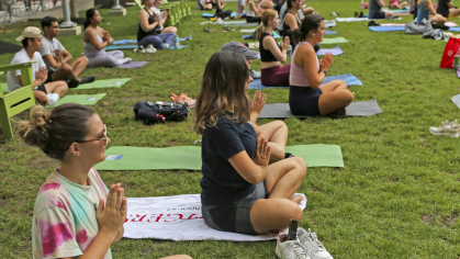 Students engaged in a yoga class outside at The Yard
