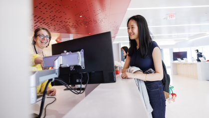 A student looking at a screen with a One Stop Employee