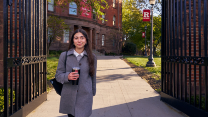 Isabella Esposito, dressed in professional attire, walking through the Class of 1882 gate