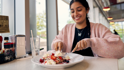 Eesha Singh eating a crepe at Henry's Diner