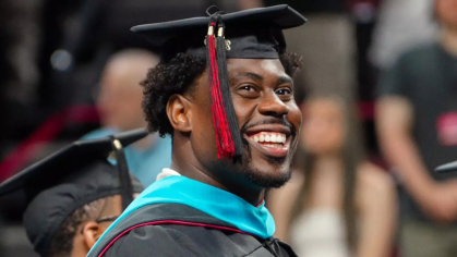Sebastian Joseph at commencement convocation wearing regalia and smiling