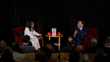 Chancellor Conway sitting on a stage speaking with Freeman Hrabowski