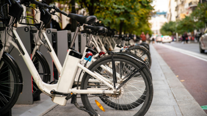 A row of electric bikes parked on a sidewalk