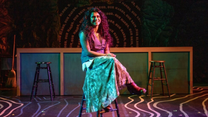 Maya Ramdayal sitting on a stool in front of a set