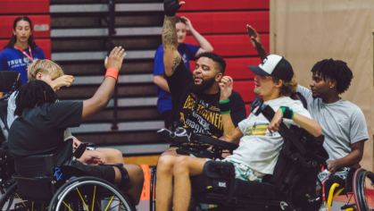 Anthony Guzman, who uses a wheelchair, cheers with other members of True Grit after a basketball game last year.