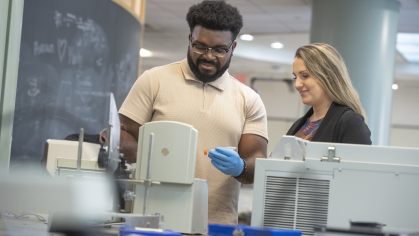 Two students in a lab performing a test