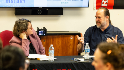 Two faculty members chatting at a round table