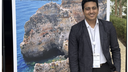 Student featured in front of the ISCC 2026 conference banner