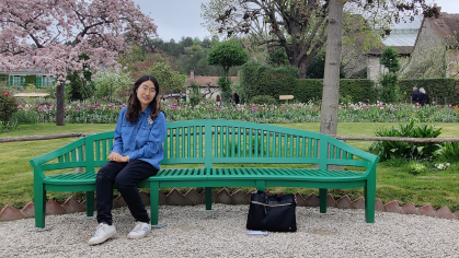 Honors College student Trisha Yu sitting on a bench in Giverny, France.