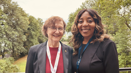 Eva Andrea and Chancellor Conway in front of scenery with trees
