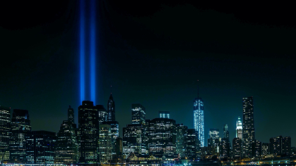The New York City skyline at night showing "Tribute in Light," an annual public art installation that projects twin beams into the night sky to honor the victims of the September 11 attacks