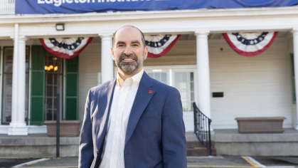 A man, Nick Longo, smiling in front of the Eagleton Institute of Politics