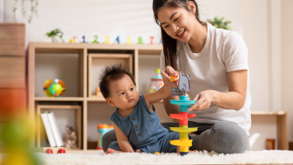 A woman playing and teaching her baby