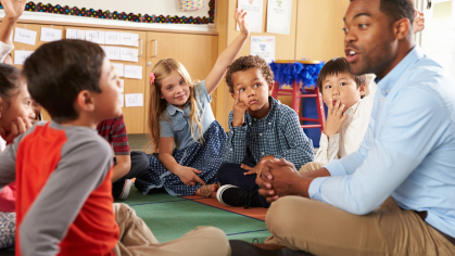 Teacher sitting down with a group of students