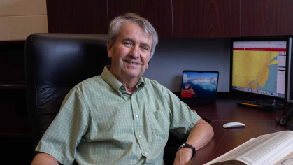 Man in green shirt at his desk