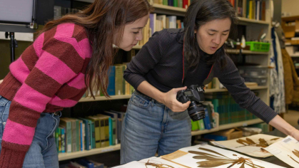 Asem Kiyalova (left), a Rutgers graduate student and research assistant, and Sue Huang examine plant specimens housed at the Chrysler Herbarium.
