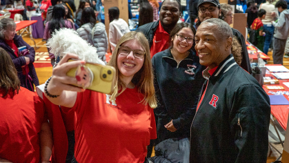 A student representative of Rutgers Athletic Bands snaps a photo with Rutgers University President William F. Tate IV in the College Avenue Gymnasium.