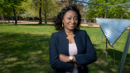 Chinwe Mercy Izegbu standing with her arms folded outside on campus