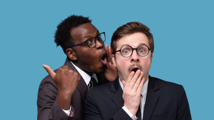 Office worker whispering into coworkers ear