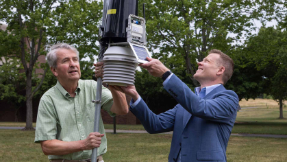 Two men set up a weather station on the Rutgers Livingston Campus