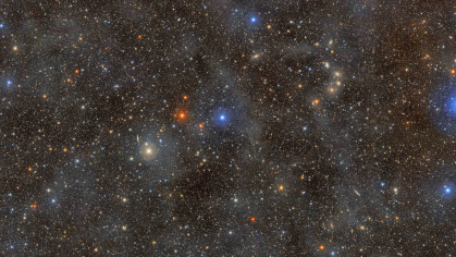 A telescope image of deep space, black in the background and littered with stars.