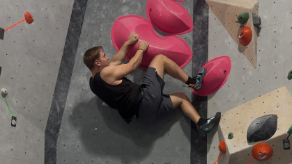 Rutgers graduate Christopher Slipiec scales a rock wall in an indoor space in Warsaw.
