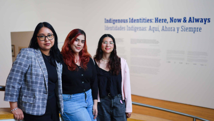 Museum educator Jessie Garcia (left), undergraduate student Karla Masin and graduate student Hanna Cherres stand before wall text presented in English and Spanish inside the Zimmerli.