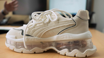 A white sneaker with electronics in its nearly see-through heel.