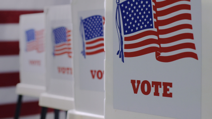 A succession of voting booths with the American flag and the word "Vote" written on each