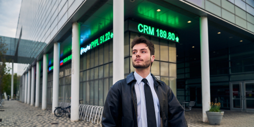 male student walking next to the business school