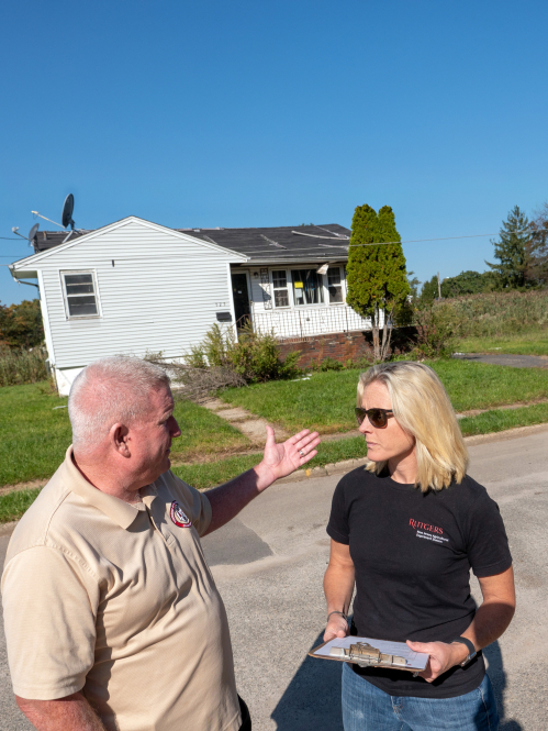 Researcher and community member discussing flood damage.
