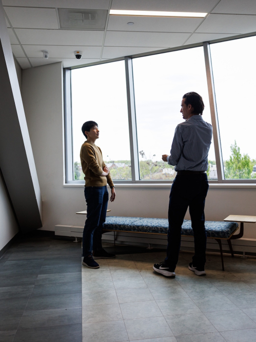 Two professionals talking in front of a window