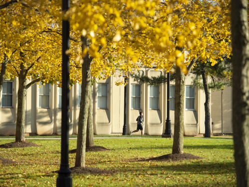 Student jogs by the Engineering Building on a sunny fall afternoon
