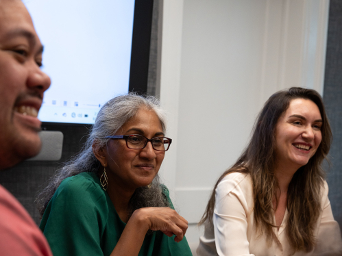 A group of college professors laughing together at a table
