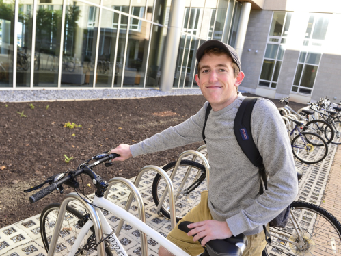 Noah Miller (RBS '19) retrieving his bike from the bike rack