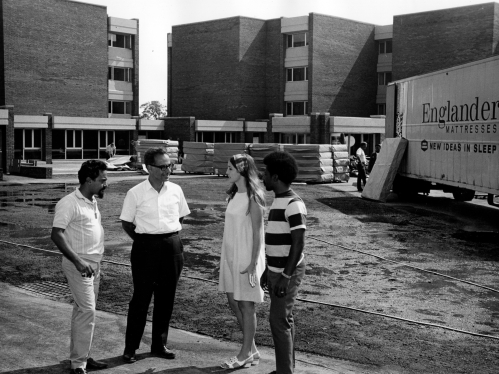 Four people talking while construction for Livingston takes place in the background
