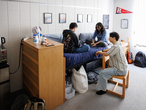 Students hanging out and playing cards in a dorm room