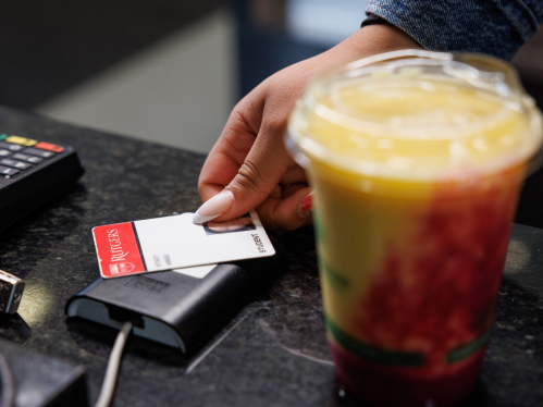 A student paying for coffee by swiping their RU ID card