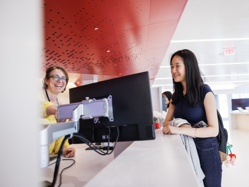 A student looking at a screen with a One Stop Employee