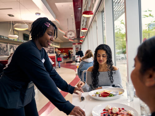 Eesha Singh and Keerthana Kothapalli being served lunch by waitress Jelania Johnson at Henry's Diner