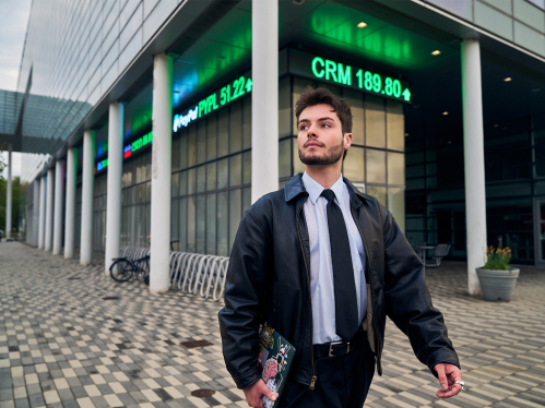 male student walking next to the business school