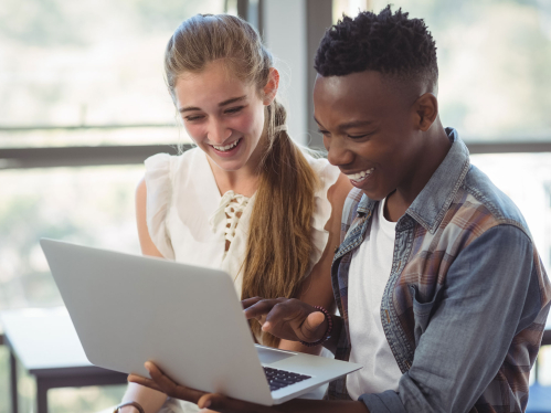 two students looking at a laptop